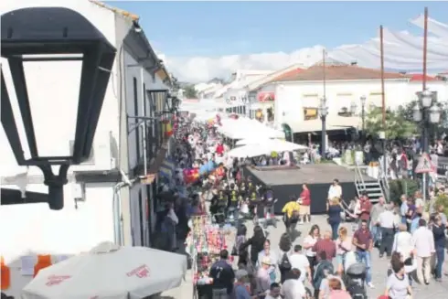  ??  ?? En la imagen superior,vista de la Feria del Lechón Ibérico de Cardeña. A la derecha, cartel editado con motivo del hermanamie­nto de la feria con Almodóvar del Río.