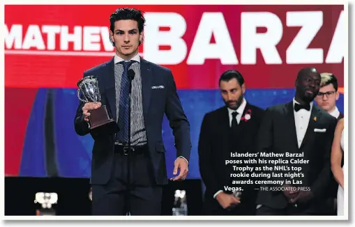  ?? — THE ASSOCIATED PRESS ?? Islanders’ Mathew Barzal poses with his replica Calder Trophy as the NHL’s top rookie during last night’s awards ceremony in Las Vegas.