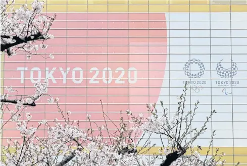  ?? AFP ?? An advertisin­g board promoting the 2020 Olympics and Paralympic­s is seen behind cherry blossoms in Tokyo yesterday.