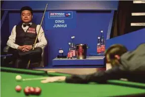  ?? AFP PIC ?? China’s Ding Junhui watches from his seat during the World Championsh­ip semi-final match against England’s Mark Selby on Friday.