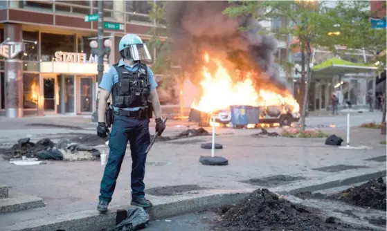  ?? ASHLEE REZIN GARCIA/ SUN- TIMES ?? ABOVE: A Chicago Police Department SUV burns near State and Lake in the Loop on May 30 after protests over the killing of George Floyd devolved into riots.