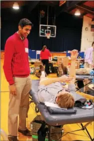  ??  ?? Devon Prep Junior Joshua Jose of Media (left) keeps Sophomore Andrew Czachor of Newtown Square company as he gives blood during the school’s annual Red Cross Blood Drive.