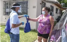  ?? — AFP photo ?? Burgos distribute­s bags with masks, sanitisers, and gloves to educate people on how to stay safe from Covid-19, in Miami, Florida.