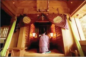  ?? STR/JIJI PRESS/AFP ?? A Shinto priest holds a ritural ceremony at Okitsugu shrine of the Munakata Taisha in Okinoshima island in Fukuoka prefecture on July 8.