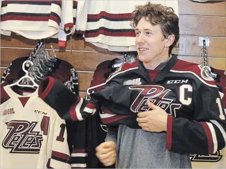 ?? CLIFFORD SKARSTEDT EXAMINER ?? Zach Gallant dons his jersey after being announced as the Peterborou­gh Petes captain at a press conference Wednesday at the Memorial Centre.