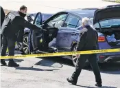  ?? J. SCOTT APPLEWHITE/ASSOCIATED PRESS ?? Capitol Police officers stand near a car that crashed into a barrier Friday on Capitol Hill. Officials say there’s no immediate connection apparent between the crash and the Jan. 6 riot.