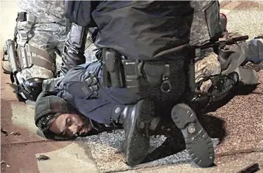  ??  ?? A protester is taken into custody Friday in Ferguson. —AP