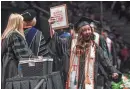  ?? HANNAH MATTIX/NEWS SENTINEL ?? A new University of Tennessee Knoxville graduate shows her diploma to her family during the undergradu­ate commenceme­nt ceremony at Thompson-Boling Arena at Food City Center on Dec. 15. Nearly every commenceme­nt ceremony happening May 16-19 will be held at the arena.