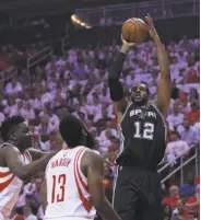  ?? Ronald Martinez / Getty Images ?? The Spurs’ LaMarcus Aldridge, who scored 26 points, shoots over Clint Capela and James Harden.