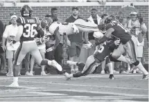  ?? AP PHOTO/ROGELIO V. SOLIS ?? Alabama running back Najee Harris leaps over Ole Miss defensive back Jalen Julius for a 10-yard touchdown during the first half of their SEC opener Saturday in Oxford, Miss. The host Rebels scored on the game’s first snap, but Alabama cruised from there to win 62-7.