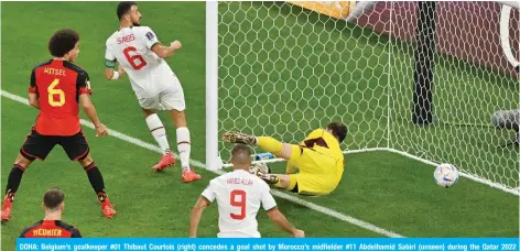  ?? — AFP ?? DOHA: Belgium’s goalkeeper #01 Thibaut Courtois (right) concedes a goal shot by Morocco’s midfielder #11 Abdelhamid Sabiri (unseen) during the Qatar 2022 World Cup Group F football match between Belgium and Morocco on November 27, 2022.