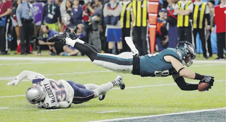  ?? FRANK FRANKLIN II/THE ASSOCIATED PRESS ?? Philadelph­ia tight end Zach Ertz dives into the end zone over New England free safety Devin McCourty for the game-winning touchdown.