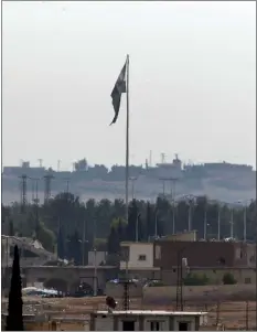  ?? LEFTERIS PITARAKIS — AP FILE ?? In this Oct. 22 photo taken from the Turkish side of the border between Turkey and Syria, in Akcakale, Sanliurfa province, southeaste­rn Turkey, Syria’s opposition flag flies on a pole in Tal Abyad, Syria. Turkey’s Defense Ministry says a car bomb went off in Tal Abyad, killing several civilians. The ministry says others were wounded when the bomb exploded Saturday, Nov. 2 in central Tal Abyad, which was captured last month by Turkey-backed opposition gunmen from Kurdish-led fighters.