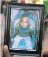  ?? MICHAEL LAUGHLIN/SUN SENTINEL ?? A photo of Noah Sneed is held during a memorial at Ceressa’s Daycare & Preschool Tuesday.