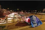  ?? Jae C. Hong/Associated Press ?? A tarp covers a portion of a homeless person’s tent on a bridge overlookin­g the 101 Freeway in Los Angeles.