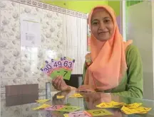  ?? FIRMA ZUHDI AL FAUZI/JAWA POS ?? UTAK-ATIK ANGKA: Niken memperliha­tkan flow card ciptaannya di lobi SD Islam Kreatif Mutiara Anak Sholeh pada Sabtu lalu (18/2).