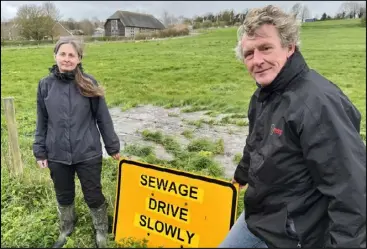  ?? ?? Speeding motorists have been splashing polluted water on to cars and houses along Abingdon Road. Green councillor Carolyne Culver shows the sign