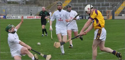  ??  ?? Wexford midfielder Colm Farrell takes aim as Buffers Alley’s Paudie Reidy attempts to block for his native Kildare.