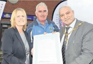  ??  ?? ●●Tony Harling, Rochdale Sports Club Secretary (centre), accepts the smoke free pledge from Coun Jacqui Beswick and deputy mayor Coun Mohammed Zaman