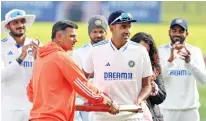  ?? ?? India’s head coach Rahul Dravid presents the 100th Test cap to Ravichandr­an Ashwin before the start of the match on Thursday