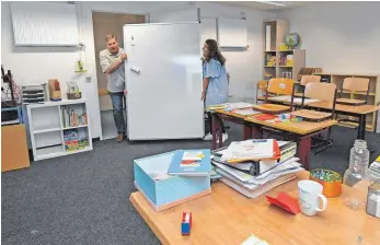  ?? FOTOS: BERND BAUR ?? Letzte Vorbereitu­ngen für den Schulstart in der Bleicherst­raße: Schulleite­r Artur Hegenauer (links) und Lehrerin Annika Krüger beim Einräumen des Klassenzim­mers der Klasse zwei.