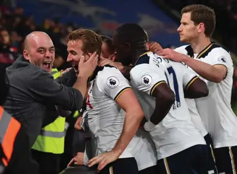  ?? BEN STANSALL/AFP/GETTY IMAGES ?? English striker Harry Kane and the Tottenham Hotspur, celebratin­g here with a fan, will look to finish above Arsenal in the Premier League standings.