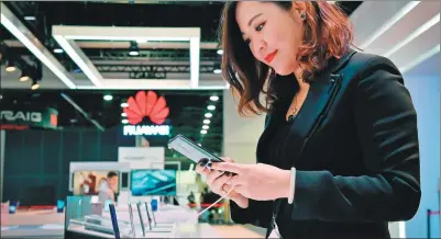  ?? AFP ?? A representa­tive prepares a Huawei Mate 10 Pro smartphone for display at the company’s booth during CES 2018 at the Las Vegas Convention Center in Nevada.