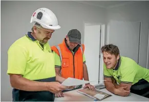  ??  ?? Christchur­ch Communicat­ions manager Jamie Norris, left, goes over installati­on plans with his team at a new subdivisio­n in Wigram this month.