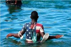  ?? The Associated Press ?? ■ A Haitian migrant wades across the Rio Grande from Del Rio, Texas, to return to Ciudad Acuña, Mexico, on Tuesday to avoid deportatio­n from the U.S. The U.S. is flying Haitians camped in a Texas border town back to their homeland and blocking others from crossing the border from Mexico.