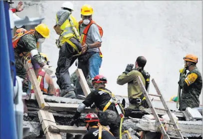  ?? Moises Castillo ?? The Associated Press Rescue workers evacuate the site of a collapsed office building Sunday in the Roma Norte neighborho­od of Mexico City.