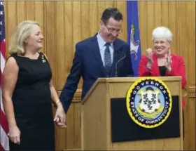  ?? SUSAN HAIGH — THE ASSOCIATED PRESS ?? Connecticu­t Gov. Dannel P. Malloy holds the hand of his wife Cathy after announcing Thursday at the Capitol in Hartford, Conn., that he will not seek a third term in 2018. Applauding is Lt. Gov. Nancy Wyman, right.