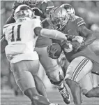  ?? KYLE ROBERTSON/COLUMBUS DISPATCH ?? Ohio State running back Miyan Williams carries the ball as Notre Dame's Howard Cross tries to pull him down by his jersey.