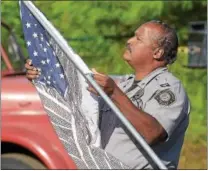  ?? PETE BANNAN – DIGITAL FIRST MEDIA ?? South Coatesvill­e Police Chief Kevin Pierce adjusts the “Flag of Honor,” which contains the names of those who perished in the terrorist attacks on Sept. 11, 2001.