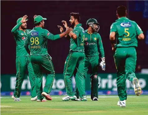  ?? Ahmed Kutty/ Gulf News ?? Pakistan’s left-arm spinner Imad Wasim (centre) once again proved to be West Indies nemesis claiming three early wickets to reduce the world champions to a paltry score 103 for five in the final Twenty20 clash at Zayed Stadium in Abu Dhabi yesterday.