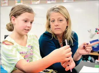  ?? LYNN KUTTER ENTERPRISE-LEADER ?? Fifth-grade Farmington science teacher Linda Flynn talks with Parker Safely about her group’s project to create a potato coring device to take a sample from a potato slice. Flynn is one of three finalists to represent Arkansas for a math and science...