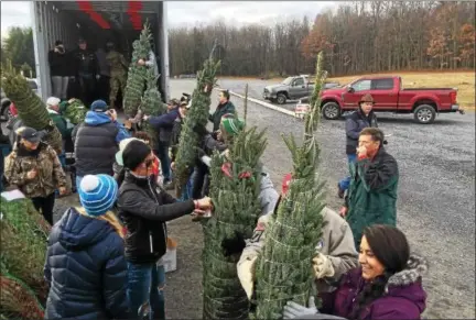  ?? PHOTOS BY PAUL POST -- PPOST@DIGITALFIR­STMEDIA.COM ?? Army National Guard, Air National Guard and Patriot Guard Riders members turned out Monday to load Christmas trees onto a truck at Ellms Family Farms as part of the nationwide Trees for Troops program.