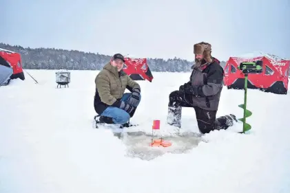  ?? ?? Chris Dorman, left, and Andrew “AJ” Beaudoin check a tip-up. They hope to turn the remote area near the Adirondack Rail Trail into a winter destinatio­n through Dorman’s Arctic Out Post shop and Beaudoin’s BattleFish Charters ice fishing village.