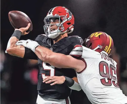  ?? BUTCH DILL/AP ?? Falcons quarterbac­k Desmond Ridder (9) passes the ball under pressure by Commanders defensive end Casey Toohill (95) during the first half on Sunday in Atlanta.