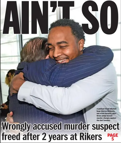  ??  ?? A jubilant Virgil Mitchell hugs Murray Richman, one of his lawyers, after Bronx judge tossed murder charges against the dad Tuesday.