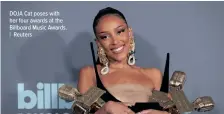  ?? DOJA Cat poses with her four awards at the Billboard Music Awards. | Reuters ??