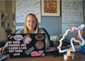  ?? Hyoung Chang, The Denver Post ?? Kristina Mccombie, a first-grade teacher at Stevens Elementary in Jeffco Public Schools, is preparing for online class at her home in Arvada on March 26. Mccombie has been figuring out how to teach little ones remotely who can't fully read yet and have short attention spans. Mccombie has brought some of the comforts of her classroom to her home like posters and a stuffed animal the kids normally pass around to talk, in order to maintain some normalcy.