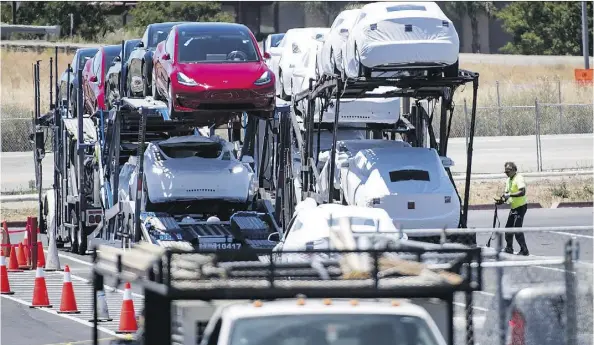  ?? DAVID PAUL MORRIS/BLOOMBERG ?? Tesla Inc. vehicles are loaded onto a truck for transport at the company’s manufactur­ing facility in Fremont, Calif., in June. Tesla is expecting to build up to 55,000 Model 3 units this quarter and has revived its goal to make 10,000 Model 3s a week sometime in 2019.