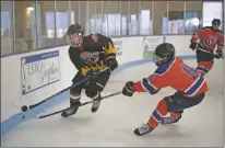  ?? Morgan Timms ?? Taos’ Leandro Richert and Amarillo’s Jaxen Andersen fight for control of the puck Sunday (Nov. 18) during Taos’ 6-7 loss to the Amarillo Bulls at the Taos Youth &amp; Family Center ice rink.