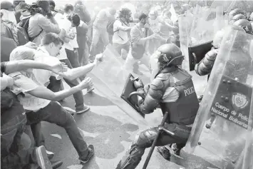  ??  ?? Anti-government protesters clash with police during a protest in Caracas. — Reuters photo