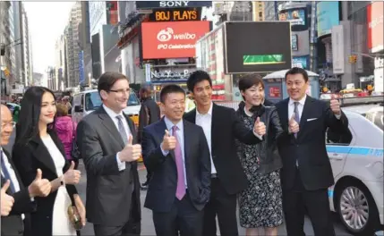  ?? MICHAEL BARRIS / CHINA DAILY ?? Charles Chao (fourth from left), chairman and CEO of Sina Corp, is joined by Chinese-American singer and songwriter Lee-Hom Wang (third from right) and other guests, celebratin­g the IPO of Weibo Corp, the microblogg­ing service owned by Sina, outside...