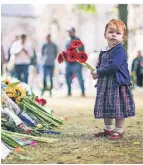  ?? FOTO: AP ?? Ein Kind mit Blumen vor dem Holyrood-Palast in Edinburgh.