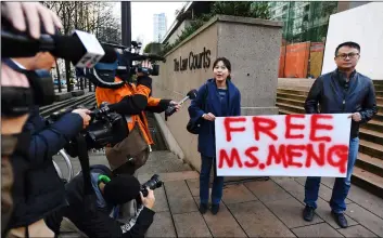  ?? JonaThan haywarD/The CanaDIan Press VIa aP ?? People hold a sign at a Vancouver, British Columbia, courthouse prior to the bail hearing for Meng Wanzhou, Huawei’s chief financial officer on Monday.