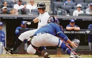  ?? Al Bello / Getty Images ?? The Yankees’ DJ LeMahieu scores past Blue Jays catcher Alejandro Kirk in the sixth inning on Wednesday in New York.