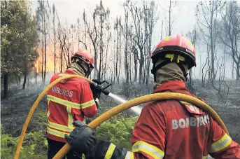  ?? AP PHOTOS ?? Portuguese firefighte­rs work to stop a forest fire from reaching the village of Figueiro dos Vinhos central Portugal, yesterday. Portugal’s president says the country’s pain “knows no end” as it mourns at least 61 people killed in the deadliest...