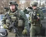  ?? Associated Press photo ?? Police officers armed with rifles gather at the scene where an active shooter was reported in Aurora, Ill., Friday.